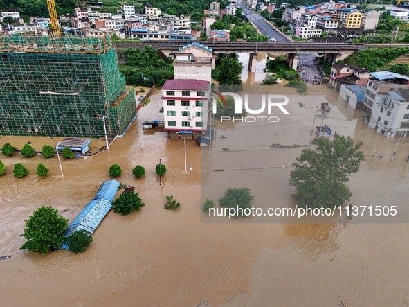 Aerial photo is showing houses and fields along the Wuyang River's Cenggong and Zhenyuan Yangping sections being flooded in Qiandongnan Pref...