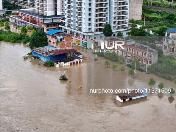 Aerial photo is showing houses and fields along the Wuyang River's Cenggong and Zhenyuan Yangping sections being flooded in Qiandongnan Pref...