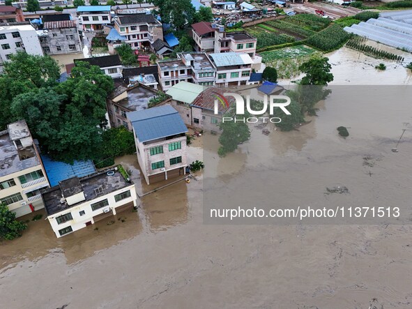 Aerial photo is showing houses and fields along the Wuyang River's Cenggong and Zhenyuan Yangping sections being flooded in Qiandongnan Pref...