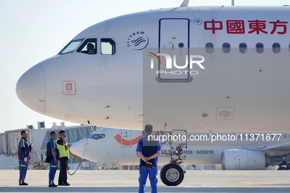 Ground staff are making preparations for a China Eastern Airlines A320 at Yantai Penglai International Airport in Yantai, China, on June 28,...