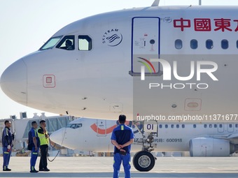 Ground staff are making preparations for a China Eastern Airlines A320 at Yantai Penglai International Airport in Yantai, China, on June 28,...