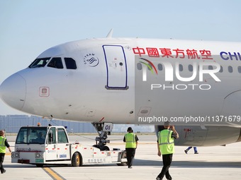 Ground staff are making preparations for a China Eastern Airlines A320 at Yantai Penglai International Airport in Yantai, China, on June 28,...