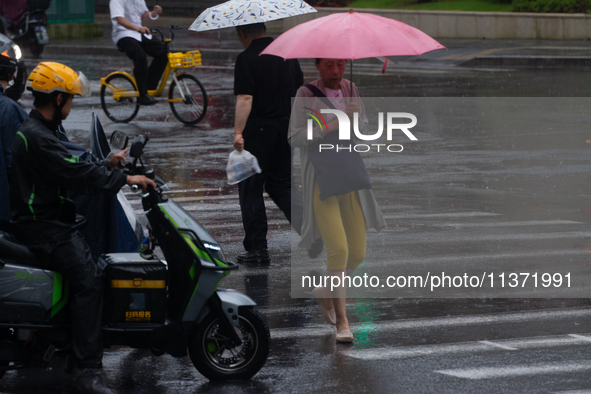 A woman is walking with an umbrella in stormy weather in Shanghai, China, on June 30, 2024. 