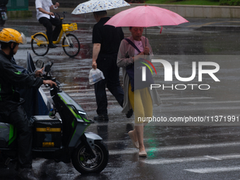 A woman is walking with an umbrella in stormy weather in Shanghai, China, on June 30, 2024. (