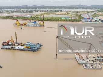 A large cutter suction dredger is under construction near the Qinjiang River Bridge at the mouth of the Qinjiang River in Qinzhou, China, on...