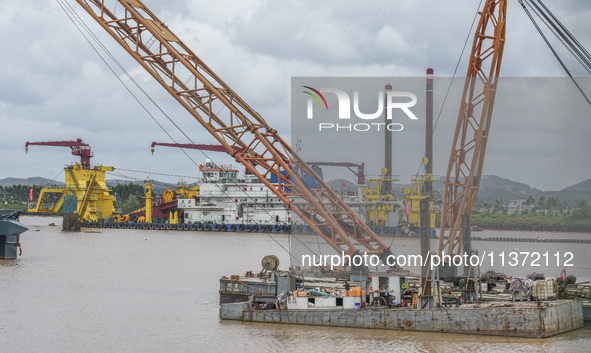 A large cutter suction dredger is under construction near the Qinjiang River Bridge at the mouth of the Qinjiang River in Qinzhou, China, on...