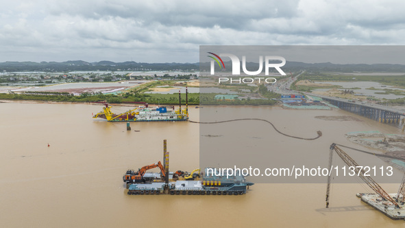 A large cutter suction dredger is under construction near the Qinjiang River Bridge at the mouth of the Qinjiang River in Qinzhou, China, on...