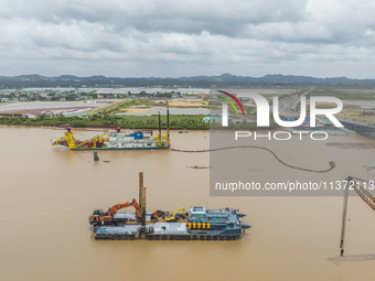 A large cutter suction dredger is under construction near the Qinjiang River Bridge at the mouth of the Qinjiang River in Qinzhou, China, on...