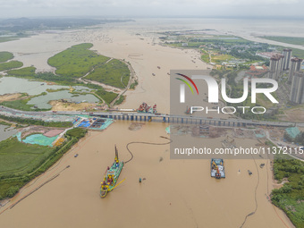 A large cutter suction dredger is under construction near the Qinjiang River Bridge at the mouth of the Qinjiang River in Qinzhou, China, on...