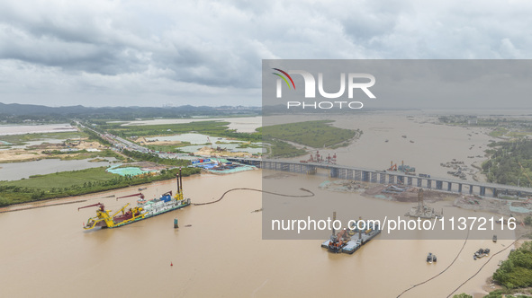 A large cutter suction dredger is under construction near the Qinjiang River Bridge at the mouth of the Qinjiang River in Qinzhou, China, on...