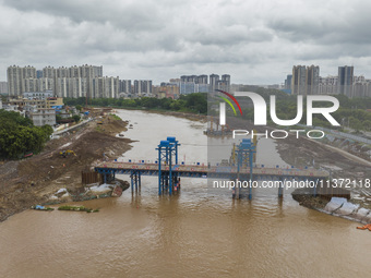 A photo is showing the construction site near Baotong Bridge of Shajing Qinjiang Bridge in Qinzhou, China, on June 29, 2024. (