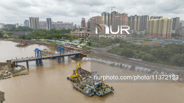 A photo is showing the construction site near Baotong Bridge of Shajing Qinjiang Bridge in Qinzhou, China, on June 29, 2024. 