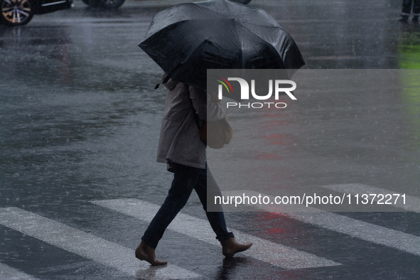 A woman is walking with an umbrella in stormy weather in Shanghai, China, on June 30, 2024. 