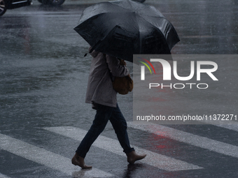 A woman is walking with an umbrella in stormy weather in Shanghai, China, on June 30, 2024. (