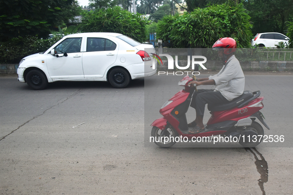 A person is riding an electric scooter in Kolkata, India, on June 30, 2024. 