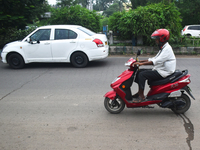 A person is riding an electric scooter in Kolkata, India, on June 30, 2024. (