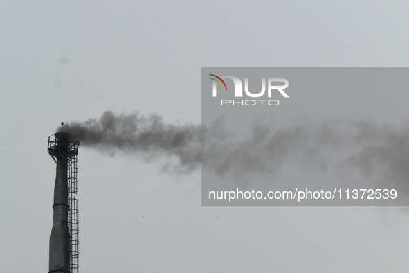 Smoke is emitting from a chimney of a factory in an industrial area on the outskirts of Kolkata, India, on June 30, 2024. 