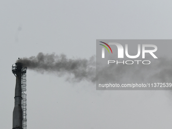 Smoke is emitting from a chimney of a factory in an industrial area on the outskirts of Kolkata, India, on June 30, 2024. (