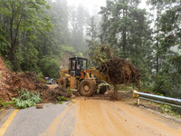 Workers are driving machinery to clear a collapsed road section at Bingmei Street in Congjiang county, Southwest China's Guizhou province, i...