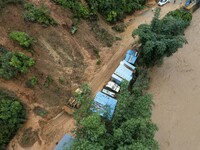 Workers are driving machinery to clear a collapsed road section at Bingmei Street in Congjiang county, Southwest China's Guizhou province, i...