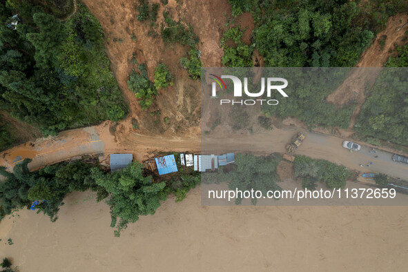 Workers are driving machinery to clear a collapsed road section at Bingmei Street in Congjiang county, Southwest China's Guizhou province, i...