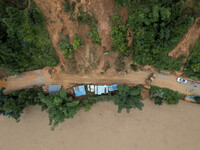 Workers are driving machinery to clear a collapsed road section at Bingmei Street in Congjiang county, Southwest China's Guizhou province, i...