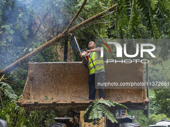 Workers are driving machinery to clear a collapsed road section at Bingmei Street in Congjiang county, Southwest China's Guizhou province, i...