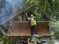 Workers are driving machinery to clear a collapsed road section at Bingmei Street in Congjiang county, Southwest China's Guizhou province, i...