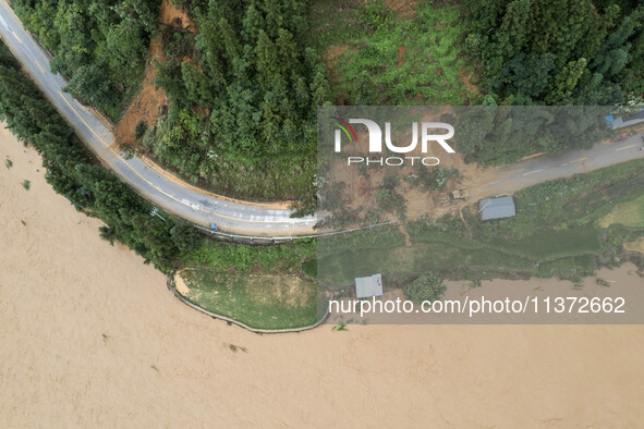 Workers are driving machinery to clear a collapsed road section at Bingmei Street in Congjiang county, Southwest China's Guizhou province, i...