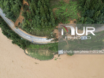 Workers are driving machinery to clear a collapsed road section at Bingmei Street in Congjiang county, Southwest China's Guizhou province, i...