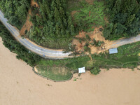 Workers are driving machinery to clear a collapsed road section at Bingmei Street in Congjiang county, Southwest China's Guizhou province, i...