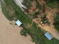 Workers are driving machinery to clear a collapsed road section at Bingmei Street in Congjiang county, Southwest China's Guizhou province, i...