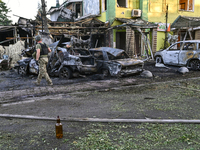 A man is walking past cars and a building destroyed by the Russian missile strike in central Vilniansk, Zaporizhzhia region, southern Ukrain...