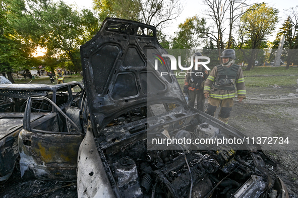 Rescuers are looking at a destroyed car during a response effort to the Russian missile attack in central Vilniansk, Zaporizhzhia region, so...