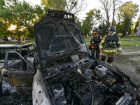 Rescuers are looking at a destroyed car during a response effort to the Russian missile attack in central Vilniansk, Zaporizhzhia region, so...