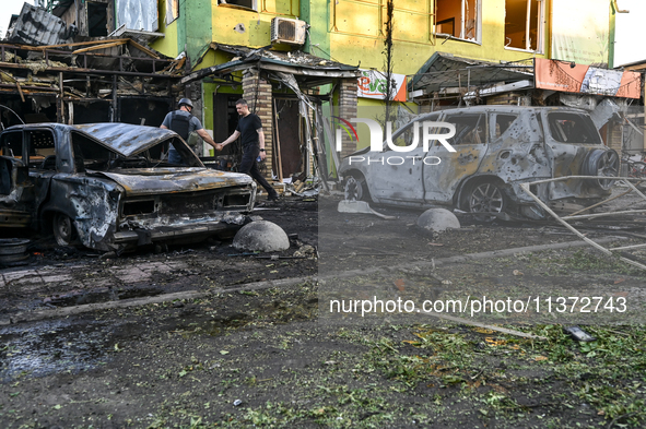 Cars and a building are being damaged by the Russian missile strike in central Vilniansk, Zaporizhzhia region, southern Ukraine, on June 29,...