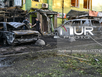 Cars and a building are being damaged by the Russian missile strike in central Vilniansk, Zaporizhzhia region, southern Ukraine, on June 29,...