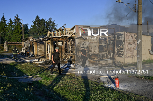 Rescuers are walking past the body of a person killed by the Russian missile attack in central Vilniansk, Zaporizhzhia region, southern Ukra...