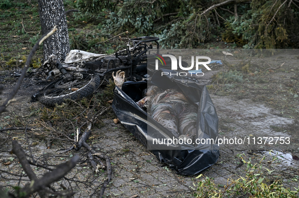 The body of a victim is lying on the ground in a body bag during a response effort to the Russian missile attack in central Vilniansk, Zapor...