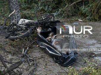 The body of a victim is lying on the ground in a body bag during a response effort to the Russian missile attack in central Vilniansk, Zapor...