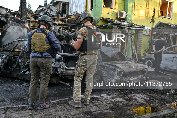 Criminal experts are examining cars destroyed by the Russian missile strike in central Vilniansk, Zaporizhzhia region, southern Ukraine, on...