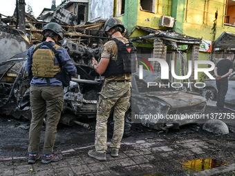 Criminal experts are examining cars destroyed by the Russian missile strike in central Vilniansk, Zaporizhzhia region, southern Ukraine, on...