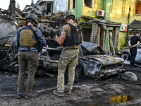 Criminal experts are examining cars destroyed by the Russian missile strike in central Vilniansk, Zaporizhzhia region, southern Ukraine, on...