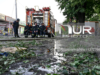 Rescuers are staying by a fire engine during a response effort to the Russian missile attack in central Vilniansk, Zaporizhzhia region, sout...