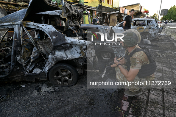 A criminal expert is examining a car destroyed by the Russian missile strike in central Vilniansk, Zaporizhzhia region, southern Ukraine, on...