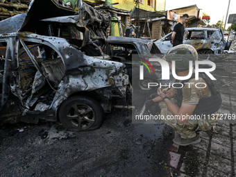 A criminal expert is examining a car destroyed by the Russian missile strike in central Vilniansk, Zaporizhzhia region, southern Ukraine, on...