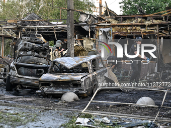 Burnt-out cars and a building are being pictured during a response effort to the Russian missile attack in central Vilniansk, Zaporizhzhia r...