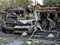 Burnt-out cars and a building are being pictured during a response effort to the Russian missile attack in central Vilniansk, Zaporizhzhia r...