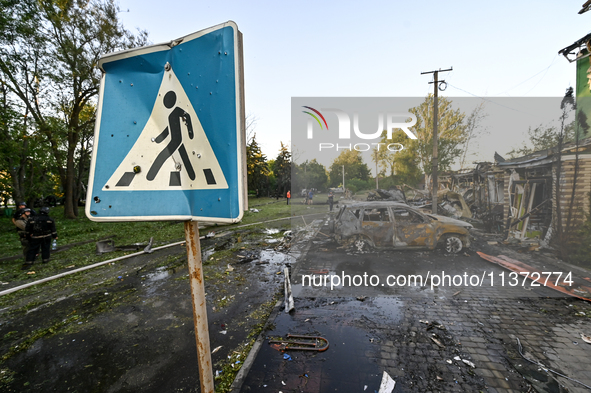 The pedestrian crossing sign is being seen near cars destroyed by the Russian missile attack in central Vilniansk, Zaporizhzhia region, sout...