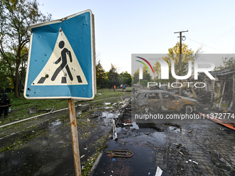 The pedestrian crossing sign is being seen near cars destroyed by the Russian missile attack in central Vilniansk, Zaporizhzhia region, sout...